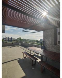 卡贝德卢Apartamento em Intermares a 100 metros do mar的天井设有2张长椅和1张位于屋顶的桌子