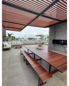 卡贝德卢Apartamento em Intermares a 100 metros do mar的庭院设有木桌和长凳