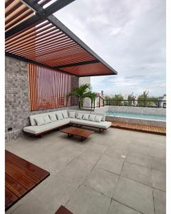 卡贝德卢Apartamento em Intermares a 100 metros do mar的庭院配有白色的沙发和桌子