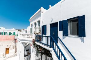 米克诺斯城Ryous Mykonos的白色的建筑,设有蓝色百叶窗和阳台