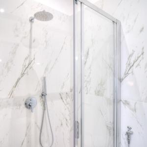 奇维塔韦基亚波尔图迪罗马酒店的浴室里设有玻璃门淋浴