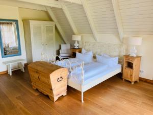 GrüssowLandhaus am Achterwasser mit Bootssteg的卧室铺有木地板,配有白色的床。