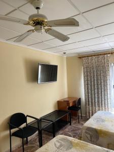阿尔卡拉德克西韦尔特Hostal Rosaleda的客房设有两张床和天花板上的电视。