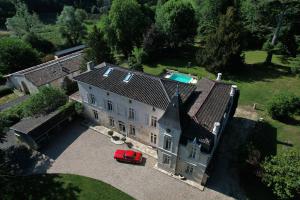 阿尔蒂盖普雷博尔多Château Fleur D'Aya的一座古老的房子,前面有一辆红色的汽车