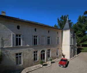 阿尔蒂盖普雷博尔多Château Fleur D'Aya的停在大楼前的红色汽车