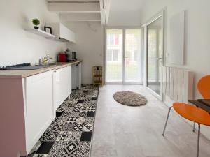 AuteuilLE COCON D'AUTEUIL - ICI CONCIERGERIE的厨房配有白色橱柜和黑白瓷砖地板。