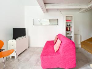 AuteuilLE COCON D'AUTEUIL - ICI CONCIERGERIE的客厅配有粉红色的沙发和电视