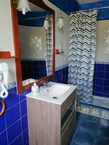 Murias de Rechivaldo弗洛尔旅馆的浴室设有水槽、镜子和蓝色瓷砖