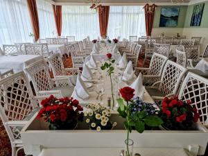 奥尔登欧登乔德酒店 的用餐室配有白色的桌椅和鲜花