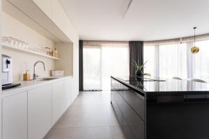 万塔西西Villa Piano的厨房配有白色橱柜和玻璃台面