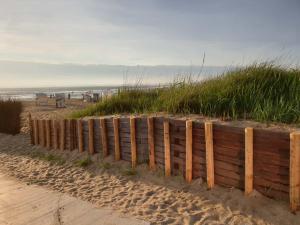 库克斯港FeWo Tietjen-Lohse, mit Meerblick, Strandhochhaus F9的海边沙滩上的木栅