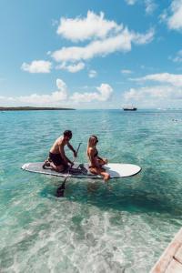 马埃堡Preskil Island Resort的两个人坐在水中的桨板上