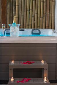 阿达玛斯Kallia's Suites Milos的浴缸配有一瓶葡萄酒和一张带灯光的桌子