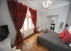勒芒德摩尔拉科莱酒店的一间卧室配有床和红色窗帘的窗户