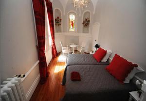 勒芒德摩尔拉科莱酒店的一间卧室配有一张带红色枕头的床和一张桌子