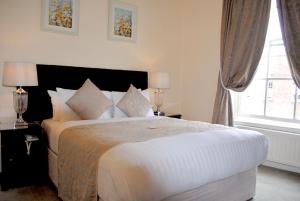 都柏林菲兹威廉姆联排别墅酒店的卧室设有一张白色大床和一扇窗户。
