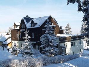 库罗阿尔滕堡克比尔旅馆的前面有雪覆盖的树木的大房子