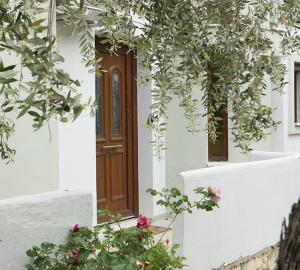 帕奇斯Olia Garden的白色的建筑,有棕色的门和一些花