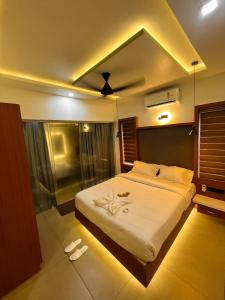 PerintalmannaBBC Luxury Apartments的一间卧室配有一张带白色床单的大床