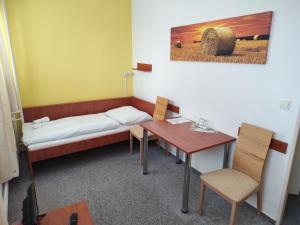 奥洛穆茨加尼贝斯特酒店的客房设有一张床、一张桌子和一张桌子。