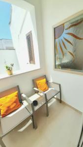 切萨雷奥港Zuccaro Apartment的一间设有两把椅子和一张桌子的房间,还有一幅画