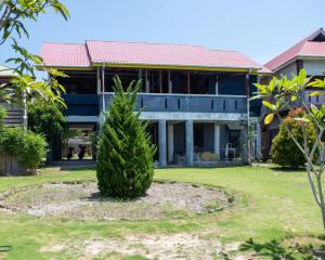 LagudriYuni Surf House的房子前面的松树