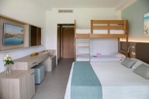 阿依纳帕海星海滩酒店的一间卧室配有两张双层床和一张书桌