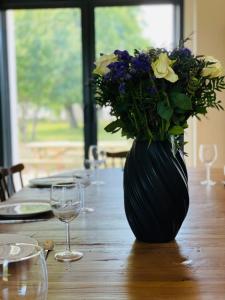 La RicheLa grange du Pigeonnier authenticity and gentleness 10 minutes from Tours的木桌上带花的黑色花瓶