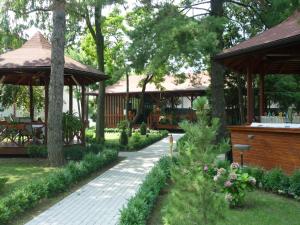 布加勒斯特巴尼萨公园酒店的花园中的一个步道,花园中设有凉亭和树木