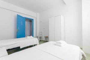 卡拉菲格拉La Marina CH的白色客房的两张床,设有蓝色门