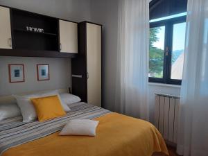 克罗诺维察Apartments Marion Klenovica的一间卧室配有一张带黄色毯子和窗户的床