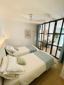 卡巴纳斯·德·塔维拉Fantástico apartamento T2 a 2min do acesso à praia CozyIn Cabanas的一间卧室设有两张床和大窗户