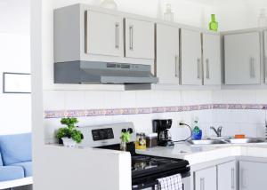 ArroyoMarina House的厨房配有白色橱柜和炉灶烤箱。