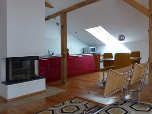 MelzowVilla am Trumpf - Design-Appartements im Naturgarten am See的一间带红色橱柜的厨房和一间客厅
