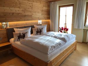 加尔米施-帕滕基兴Regina的卧室内的一张大床,设有木墙