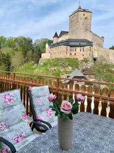 LibošoviceHotel Podkost的花瓶,桌子上花,后面有城堡
