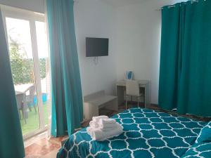 蒙泰迪普罗奇达Residence R&B Tyrrhenum的一间卧室配有蓝色窗帘和一张带毛巾的床
