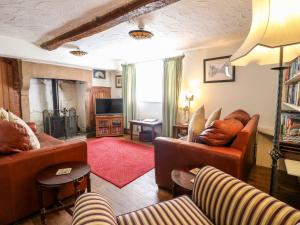 奥尔顿Staffordshire Knot Cottage的客厅配有真皮沙发和电视
