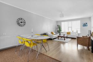 雷克雅未克Charming, 2 Bedroom Seaside Apartment的客厅配有桌子和黄色椅子