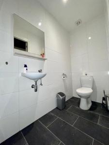 阿尔森BeejMig的白色的浴室设有卫生间和水槽。