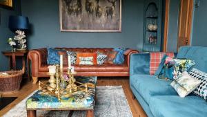 莱伯恩Rock View, Wensleydale的客厅设有棕色真皮沙发和蓝色的墙壁。