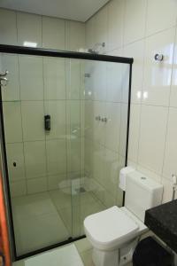 库尔韦卢Pontal Executive Hotel的一间带卫生间和玻璃淋浴间的浴室