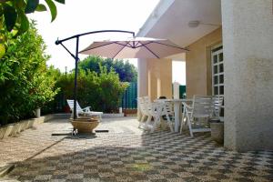 贝瓦尼亚圣彼得Villa Giovanna的庭院配有遮阳伞和桌椅。