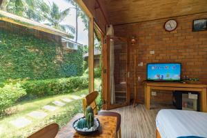 富国Dendi Resort Phu Quoc的客房设有床、电视和窗户。