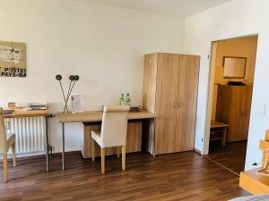 门兴格拉德巴赫Schönes Apartment in perfekter Lage的客房设有书桌、桌子和椅子