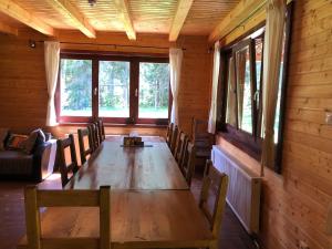 托普利察Casa de Vacanta Dintre Brazi的一间带木桌和椅子的用餐室