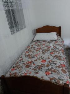 TropojëGuest House Emanueli的卧室里一张带花卉被子的床