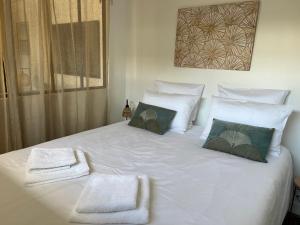 拉蒂尔巴勒Lodge LE CABANON accès direct plage !的一张白色的大床,带两条毛巾