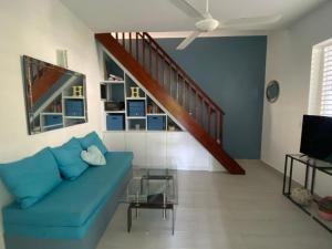 拉斯特拉纳斯Caribbean Villa Los Lobos Ballenas Beach的客厅设有蓝色的沙发和楼梯。