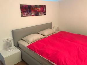菲耶Casa Sciliar centro paese PINK的一间卧室配有一张带红色毯子的床